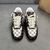 Zapatillas Louis Vuitton x Nike Air Force 1 Low By Virgil Abloh Damier Canvas Brown/White/Black: Un zapato con un patrón de lona a cuadros, marrón, blanco y negro, parte de la colaboración entre Louis Vuitton y Nike, diseñado por Virgil Abloh.