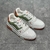 Tênis LV Trainer Branco/Verde/Laranja: Um tênis de estilo esportivo, com detalhes em verde e laranja, perfeito para um visual urbano e moderno.