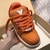 LV Trainer Maxi Orange Sneakers: Sports shoes with vibrant orange details, perfect for an urban and modern style.