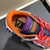 Versace Trigreca "Orange/Pink/Purple" Sneakers: Vibrant orange, pink and purple sports shoes from Versace's Trigreca line, featuring the iconic Medusa logo and high-quality details.