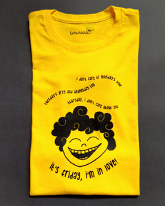 camiseta amarela com desenho de uma criança sorridente, de cabelos enrolados, com a frase " I don't care if Monday's blue/ Tuesday's grey and Wednesday too/ Thursday, I don't care about you/ It's Friday, I'm in love", em tamanho infantil, sem gênero