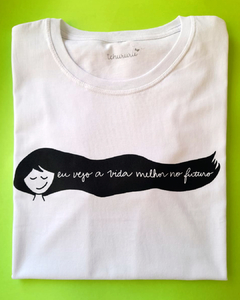 camiseta branca estampada com o desenho de um rosto de garota com cabelos longos e esvoaçantes, e a frase "eu vejo a vida melhor no futuro", em tamanho adulto, sem gênero