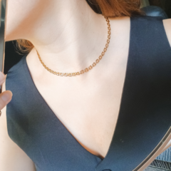 Colar choker tijolinho em ouro 18k, usado por uma mulher, com foco no detalhe do colar e na pele.