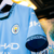 Camisa Manchester City Home 24/25 com detalhes em azul celeste e faixas diagonais em azul marinho, destacando o código 0161, na R21 Imports.