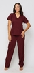 Modelo vestida com scrub feminino bordô vinho, que esta à venda, ela esta de frente. O scrub é composto por uma blusa de manga curta com decote em V e dois bolsos frontais, e uma calça combinando ele é para enfermeira, medica, fisioterapeuta, veterinaria,