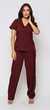 Modelo vestida com scrub feminino bordô Vinho lindo  que esta à venda, ela esta de frente. O scrub é composto por uma blusa de manga curta com decote em V e dois bolsos frontais, e uma calça combinando. 