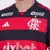 Camisa I Flamengo 2425 Masculino Torcedor com listras vermelhas e pretas, vista traseira, exibindo logotipos de patrocinadores.