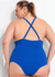 Mulher plus size usando um maiô azul, vista de costas, com alças cruzadas e acessórios elegantes.