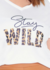 Pijama curto em malha de algodão plus size com estampa "Stay Wild" em letras grandes e fundo branco.