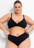 Modelo plus size usando calcinha biquíni preta transpassada em malha canelada com elástico, evidenciando o conforto e a elegância da peça.