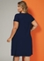 Vestido curto soltinho de cor azul marinho, com decote redondo e bolsos funcionais, ideal para tamanhos plus size, visto de costas.