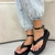 Sandálias flatform pretas com detalhe de fivela, usadas com calça jeans clara.