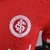 Imagem da camisa titular do Internacional 22/23, versão jogador, em vermelho com detalhes em branco, mostrando o escudo do clube e o logotipo da Adidas.