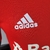 Imagem da camisa titular do Internacional 22/23, versão jogador, em vermelho com detalhes em branco, mostrando o escudo do clube e o logotipo da Adidas.