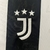 Imagem da nova camisa titular da Juventus 2024/25, com listras pretas e brancas, detalhes dourados nas mangas e na gola, escudo centralizado, logotipo da Adidas e patrocínio Jeep.