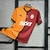 Imagem da camisa titular do Galatasaray 2024/2025 Puma com design meio a meio em laranja e amarelo, detalhes em preto e logo da Puma em vermelho.