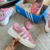 Tênis ADIDAS BAD BUNNY X CAMPUS ROSE na cor rosa, com detalhes em branco, ao lado da caixa azul da Adidas.