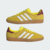 Tênis ADIDAS GAZELLE INDOOR na cor amarelo brilhante com detalhes em branco e marrom, ideal para uso casual