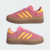 Tênis Adidas Gazelle Indoor Bold na cor rosa com detalhes em amarelo e solado transparente.