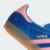 Tenis Adidas Gazelle Indoor na cor azul lúcido com detalhes em rosa.