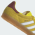 Tênis ADIDAS GAZELLE INDOOR na cor amarelo brilhante com detalhes em branco e marrom, ideal para uso casual