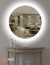 90 cm round LED mirror with halo lighting displayed in a modern living room setting.