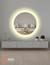 90 cm round LED mirror with a halo effect, reflecting a cozy living room setting.