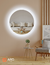 90 cm round LED mirror with a halo design, reflecting a modern living room setting with a beige couch and decorative elements.