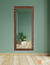 LED mirror with a wooden frame, featuring a reflective surface and plants in the background.