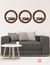 Set of three round oak mirrors above a modern gray sofa with decorative pillows and a white coffee table.