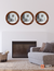 Set of three round mirrors with oak frames hanging on a white wall above a modern sofa in a stylish living room.