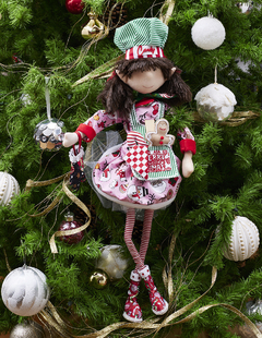 Muñeca Duenda Chef rosa "Candy" de 70 cm con gorra de chef, vestida con un vestido colorido decorado con dulces, sosteniendo una galleta de jengibre, rodeada de un árbol de Navidad.