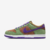 Imagem lateral do tênis Nike Dunk Low Veneer, destacando as cores verde, marrom e detalhes em roxo.