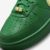 Detalhe do tênis Nike Air Force 1 x AMBUSH na cor verde, destacando o material em couro e a tag com a sigla "AF1".