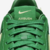 Detalhe do tênis Nike Air Force 1 x AMBUSH na cor verde, destacando o logotipo da Nike e a tag "AMBUSH".