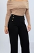 Calça wide leg preta com botões dourados, combinada com blusa de manga longa bege.