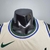 Camiseta regata bege da equipe Milwaukee Bucks, modelo masculino da Nike, destacando o detalhe do colarinho e logo.