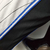 Camiseta regata branca do Orlando Magic com detalhes em azul e preto, mostrando a parte inferior e as costuras.