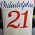 Camiseta regata branca do Philadelphia 76ers com o número 21 em destaque.