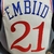 Camiseta regata bege do Philadelphia 76ers com o nome "EMBIID" e o número "21" na parte de trás.