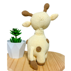 Veja os detalhes delicados e as cores vibrantes da girafa em amigurumi, ideal para adicionar um toque de safari lúdico a qualquer ambiente infantil.