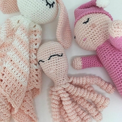 Kit de brinquedos em amigurumi para bebês recém-nascidos, incluindo uma naninha, um polvinho e um brinquedo soninho com forma arredondada para segurar. Ideal para presentes de maternidade e estimulação tátil infantil.