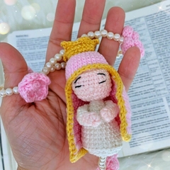 Close-up da mini Nossa Senhora em amigurumi, meticulosamente feita à mão em cores suaves, ideal para presentear ou enriquecer espaços religiosos.