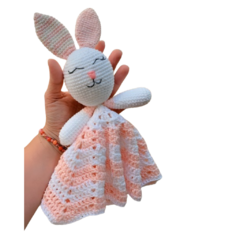 Naninha de coelha em Amigurumi, com detalhes fofos como orelhas pontudas e expressão doce, perfeita para momentos de conforto e carinho com o bebê.