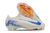 Botines Nike Mercurial Vapor 16 Elite Blueprint en color blanco con detalles azules y suela naranja, presentados con un diseño aerodinámico.