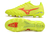 Bright yellow soccer cleats with red accents and a unique stud pattern on the sole.