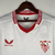 Camisa torcedor masculina branca do Sevilla FC 2023/2024 com detalhes em vermelho.