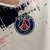 Agasalho corta vento PSG Dupla Face 2023/24 Nike na cor branca com detalhes em vermelho e azul, estampa gráfica e logo do Paris Saint-Germain.