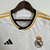 Camisa branca do Real Madrid I 2023/2024 para torcedores masculinos da Adidas, com detalhes em dourado e logo da equipe.