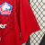 Camisa vermelha do LOSC Lille para torcedores masculinos, modelo 2024/25, com detalhes em azul e logo da New Balance.